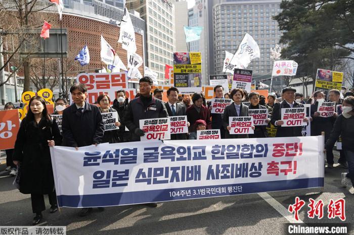 2023年3月1日，韩国民众在首尔日本驻韩大使馆附近集会，举着写有“中断屈辱外交韩日协议”等口号的抗议横幅 ...